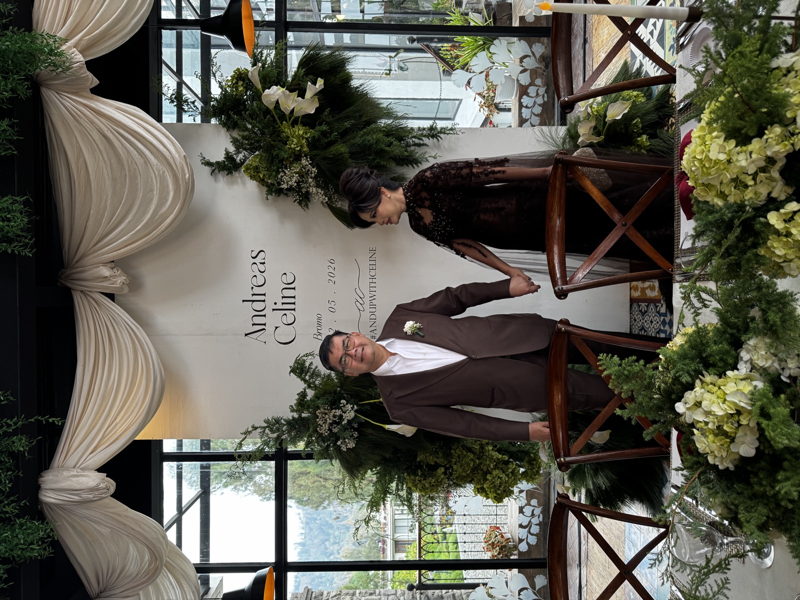 Wedding couple standing under a floral ceremony arch with Bromo scenery behind