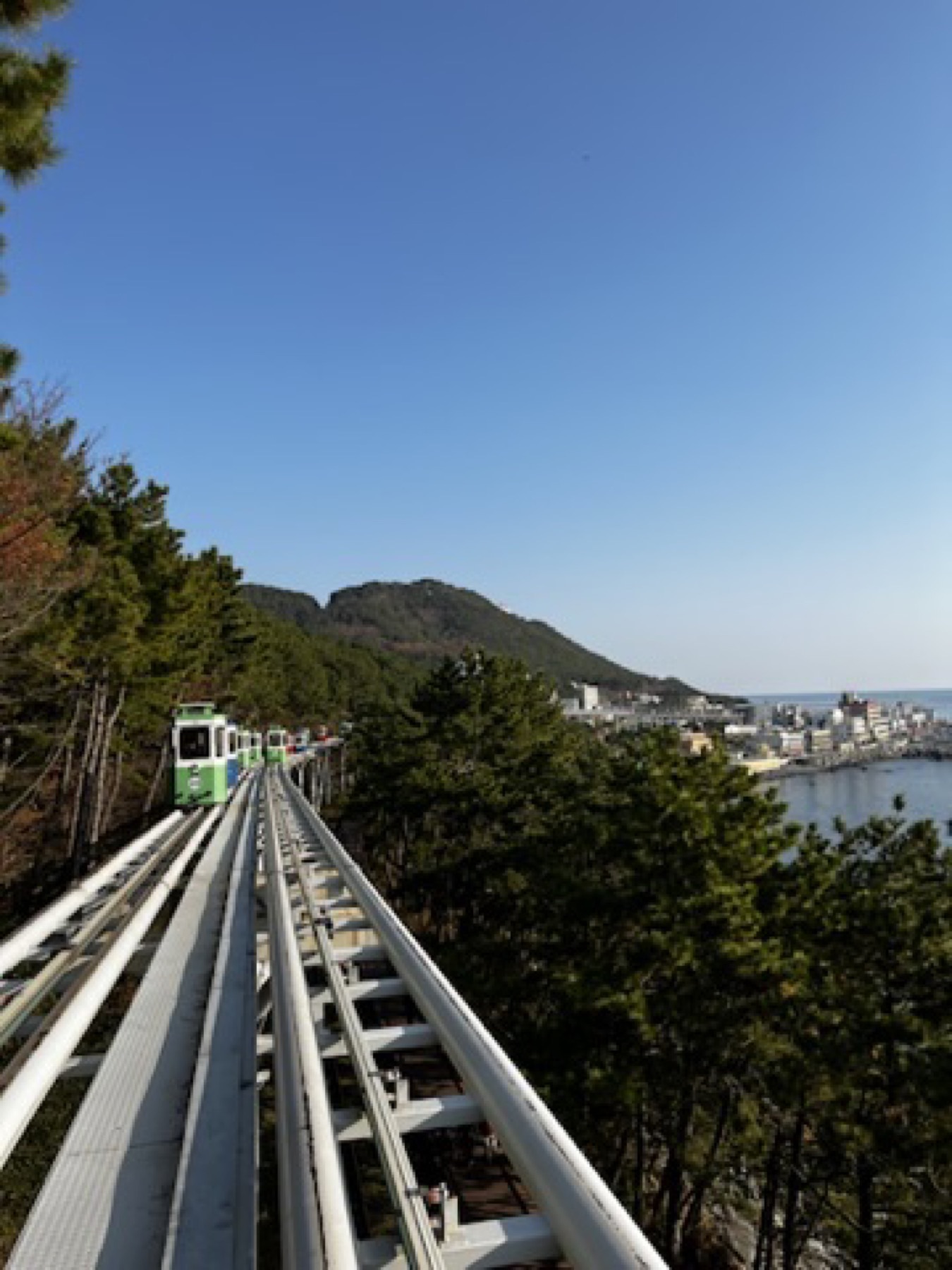 Elevated coastal rail line in Busan with sea and hillside view