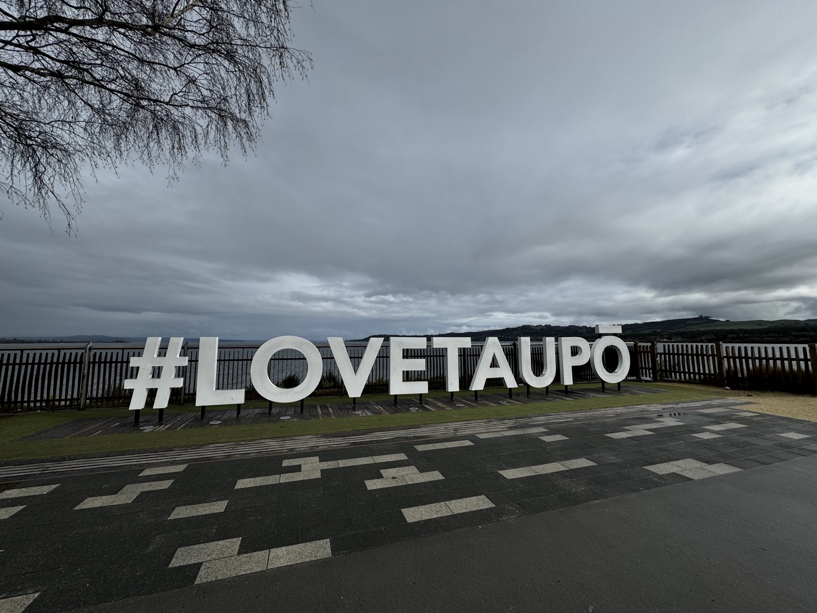 Lake Taupo sign under grey clouds
