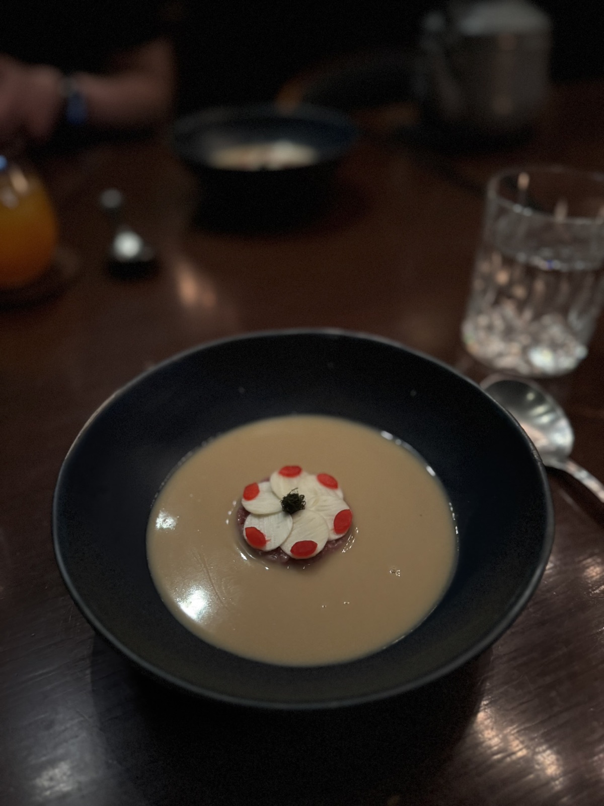 A Saawaan course with dark and green elements in a shallow bowl