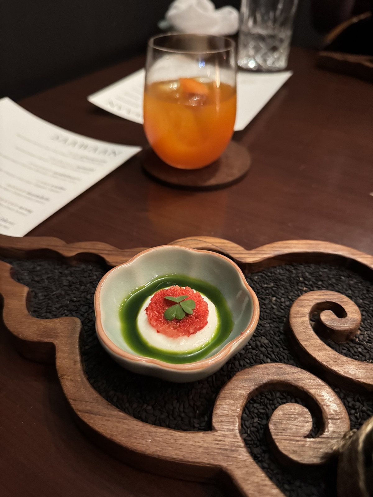 A Saawaan course with green leaves and a yellow garnish in a ceramic bowl