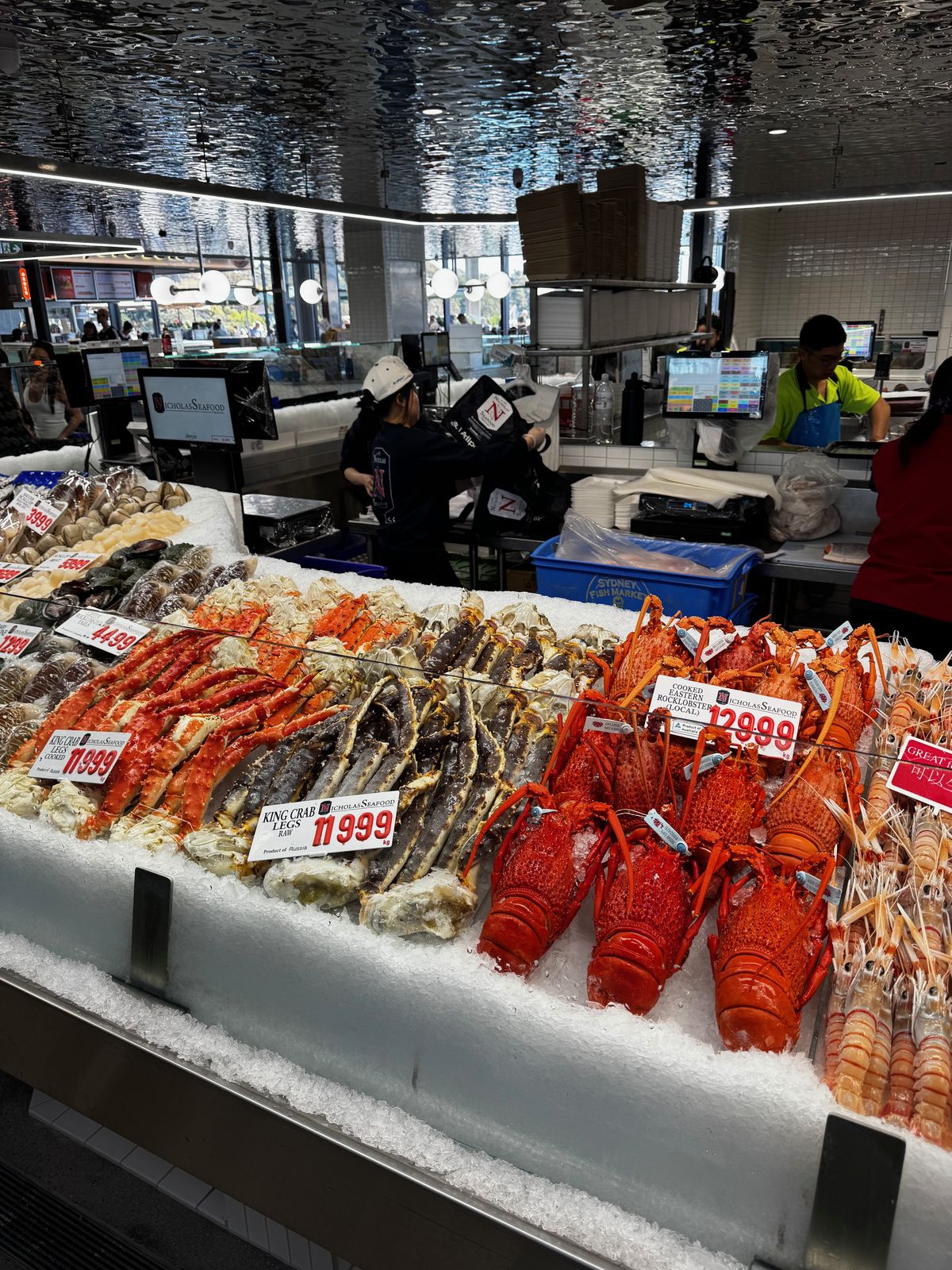 Market counter display of prawns, lobsters and shellfish on ice with price tags