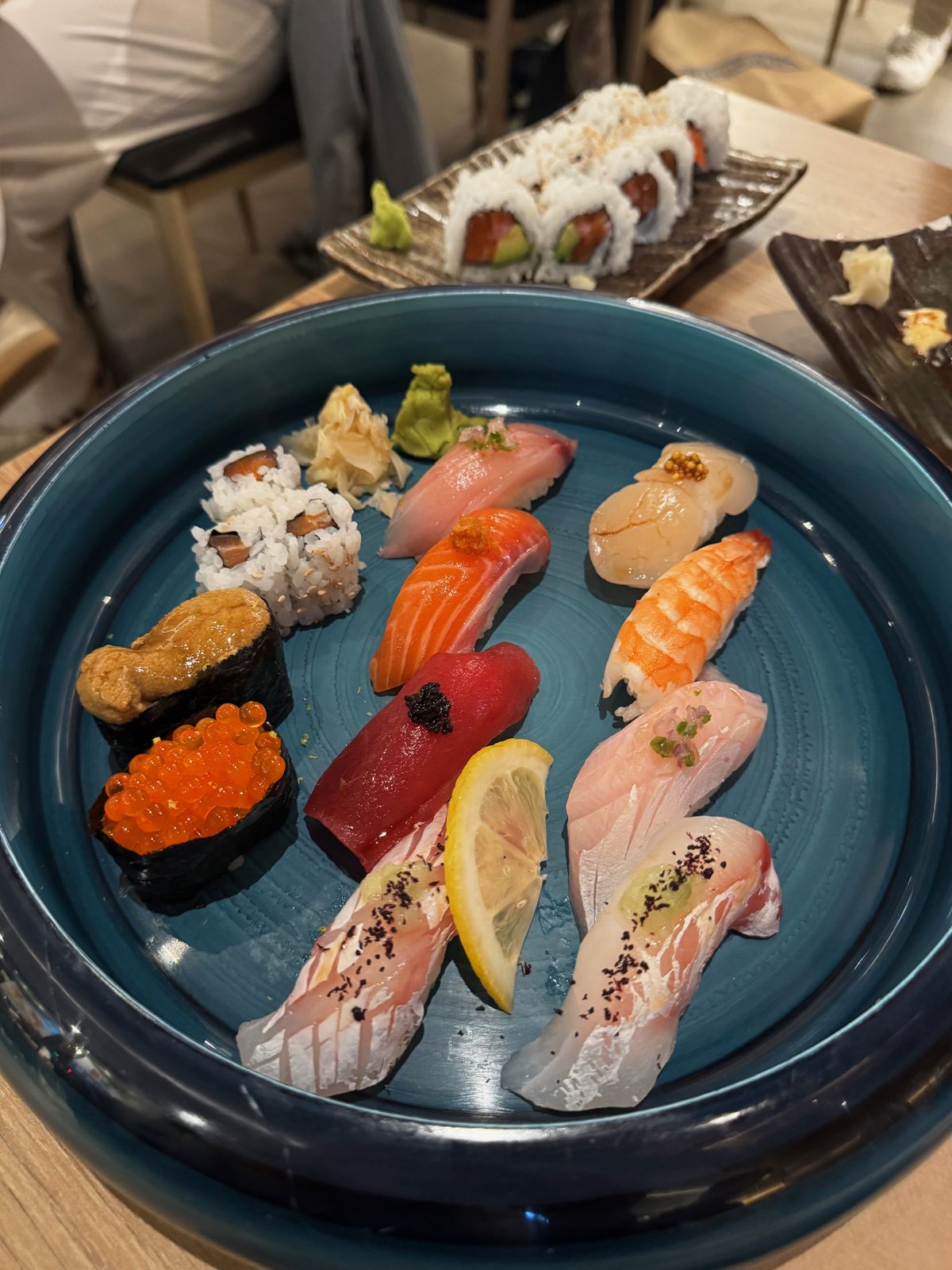 Platter of nigiri including sea urchin, salmon roe and tuna on a blue plate