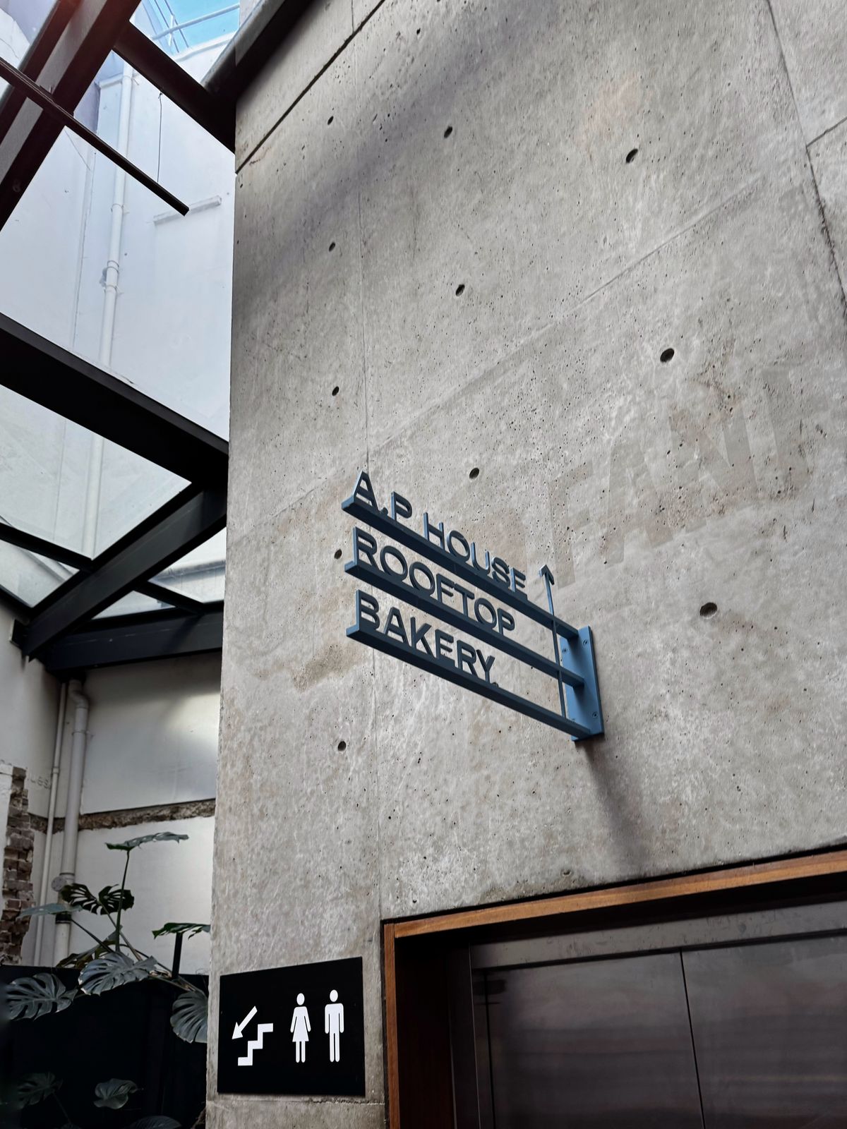 AP House Roastery and Bakery sign mounted on a concrete wall
