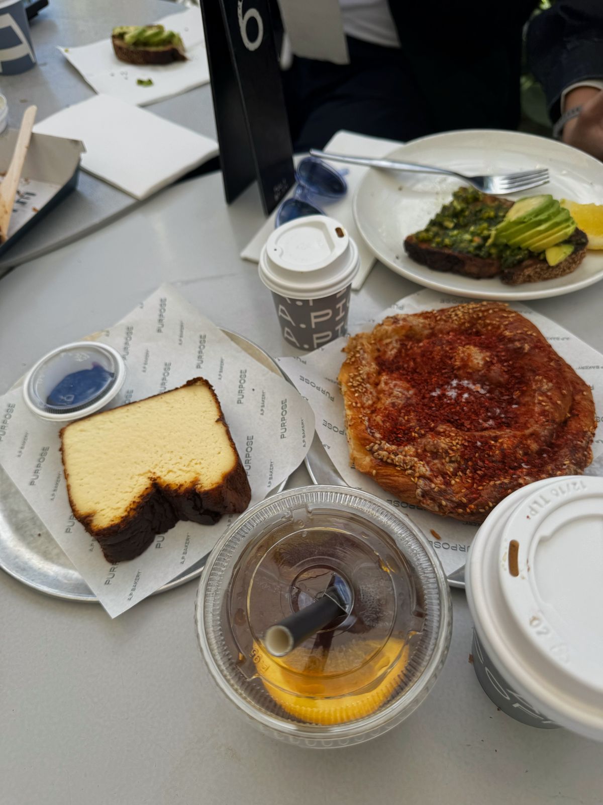 Cafe table with pastries, a slice of cake and iced drinks