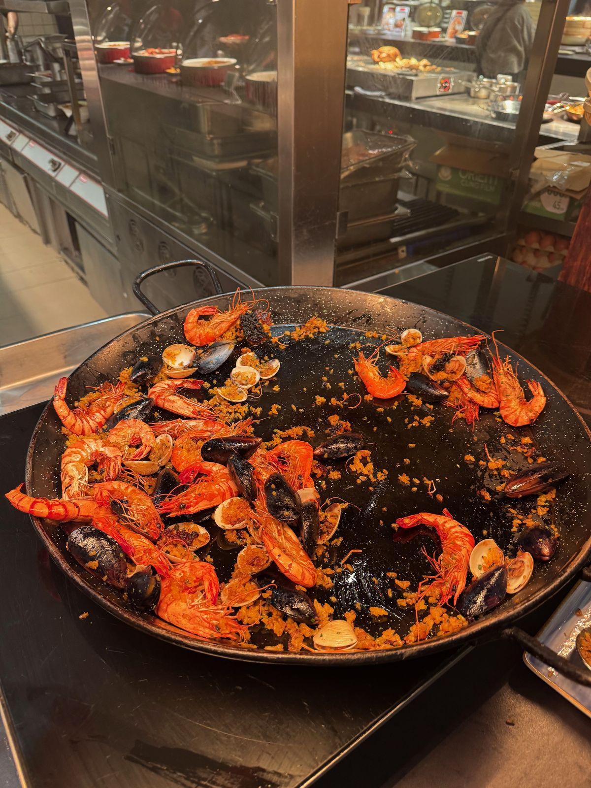 Large paella pan of rice with prawns on a hotel buffet line